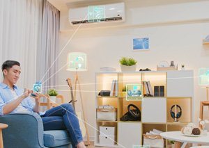 Man sitting on an armchair using a smartphone connected via smart home network overlays to household appliances
