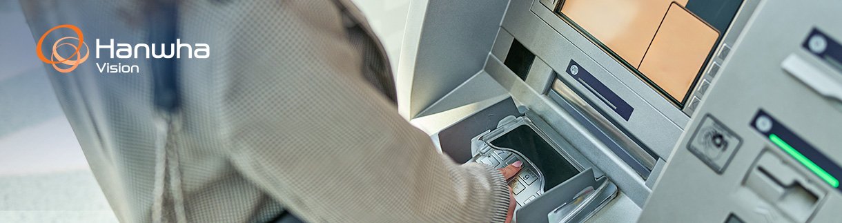 A person is using an ATM machine. The individual is inserting or retrieving a bank card from the card slot.