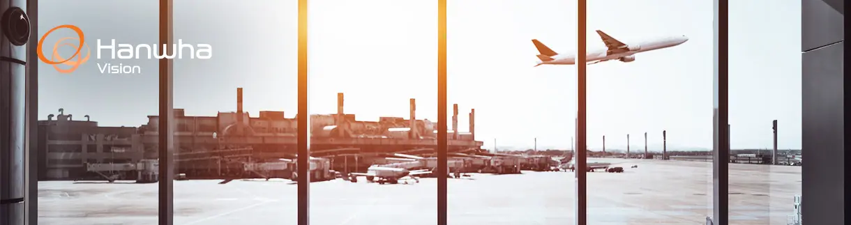 Looking out the window of an airport terminal as an airplane takes off.